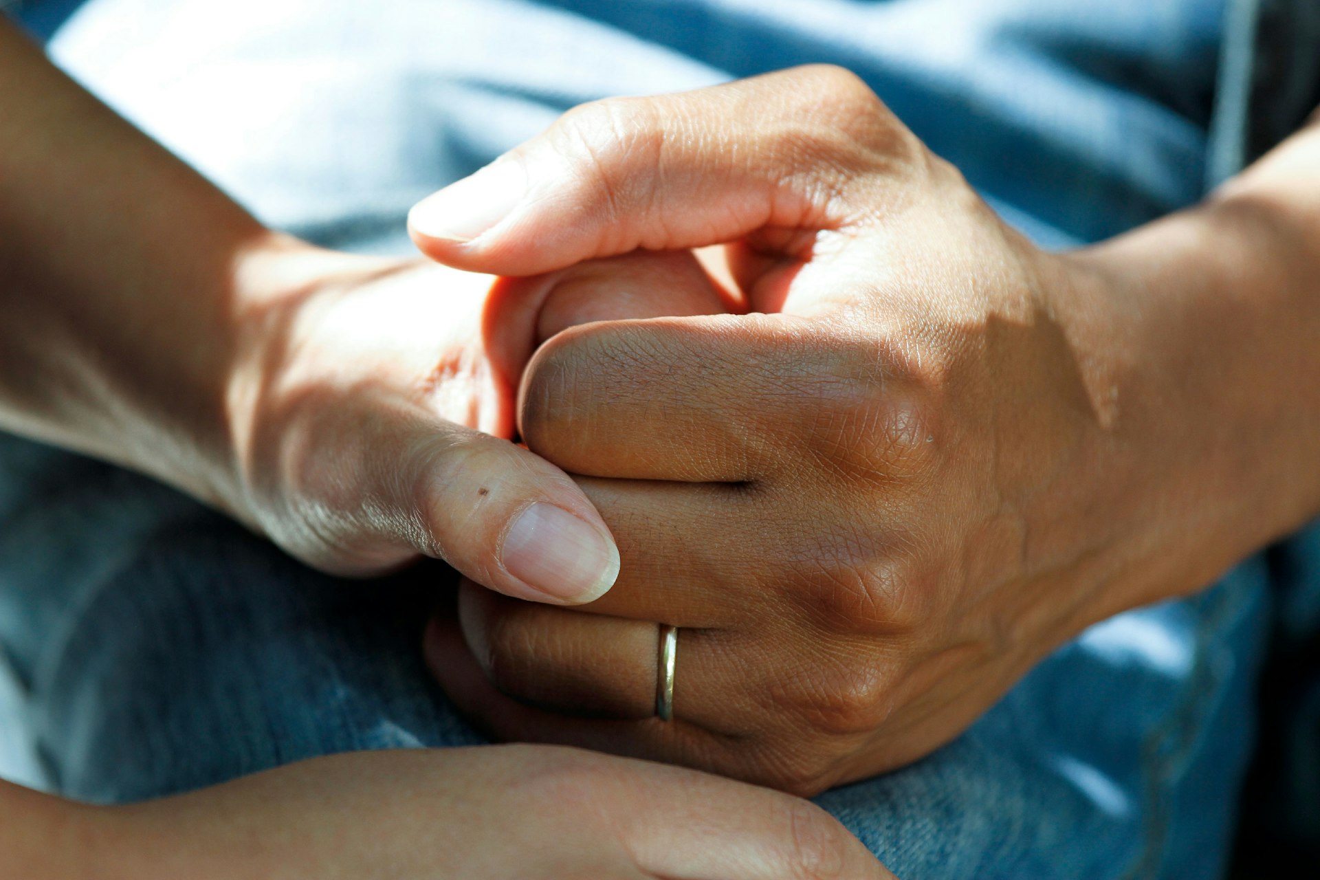 Gloved hands wiping down a stainless surface with a microfiber cloth